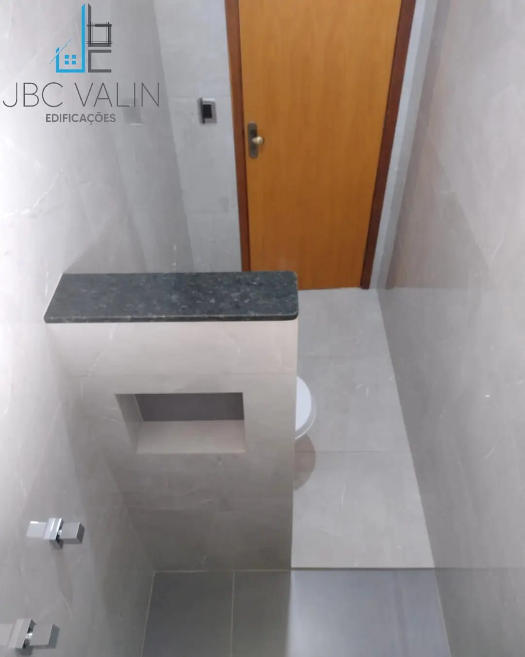 Lavabo executado em porcelanato cinza com bancada de granito