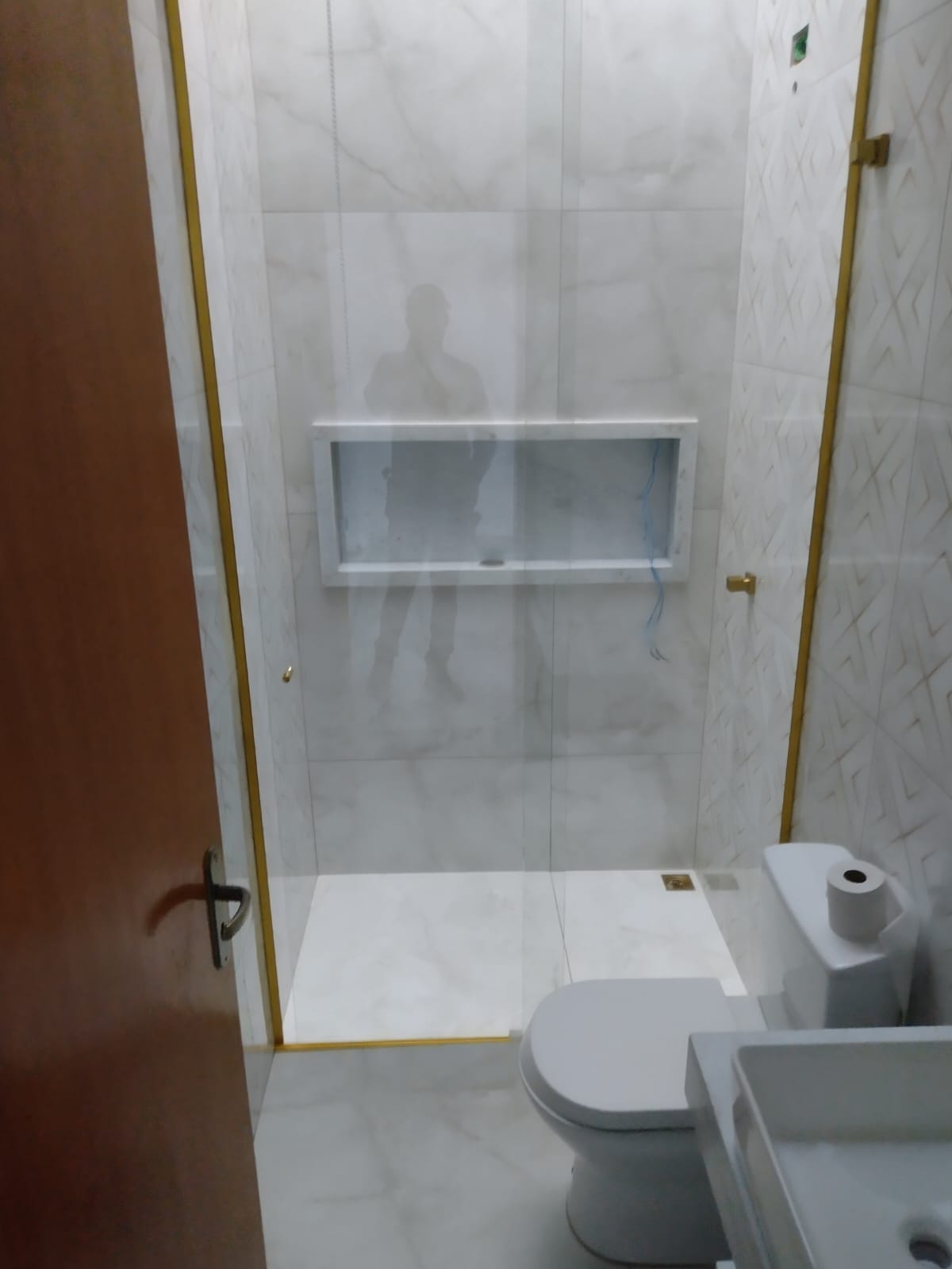 Banheiro finalizado com box de vidro e nicho embutido